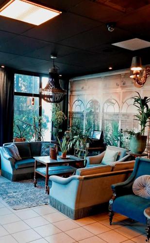 uma sala de estar com sofás e plantas na parede em Edsbyns Hotell em Edsbyn