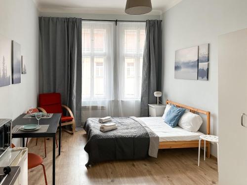 1 dormitorio con cama, escritorio y ventana en ELSO apartments, en Praga