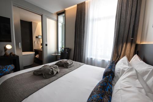 a hotel room with a bed with towels on it at Best Western Premier Le Chapitre Hotel and Spa in Remiremont