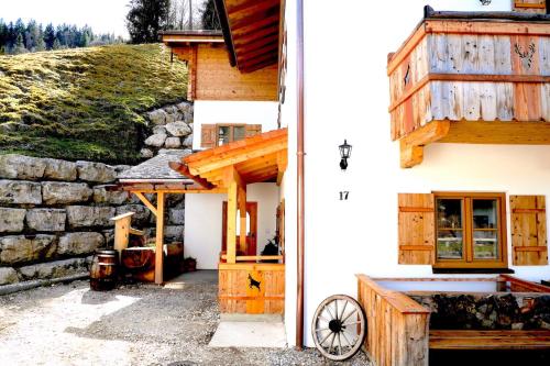 a house with a wooden door and a stone wall at Haus Kogelleiten in Ramsau