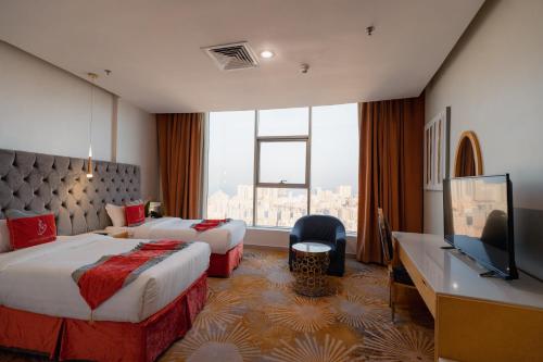 a hotel room with two beds and a large window at Wahaj Hotel Apartments 2 in Kuwait