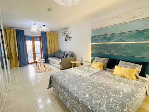1 dormitorio con 1 cama grande y 1 sofá en SEAVIEW PORT ROYAL, Los Cristianos, Heated Pool, WiFi, en Los Cristianos