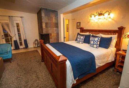 a bedroom with a large bed with blue pillows at Old Ranch Inn - Adults Only 21 & Up in Palm Springs