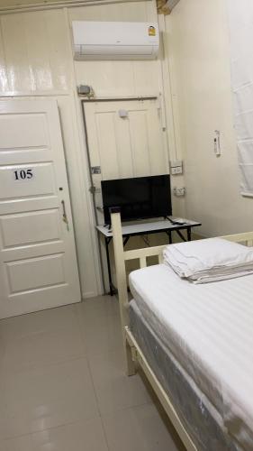 a bedroom with a bed and a desk with a television at Anna Hostel in Chaiyaphum in Ban Sieo