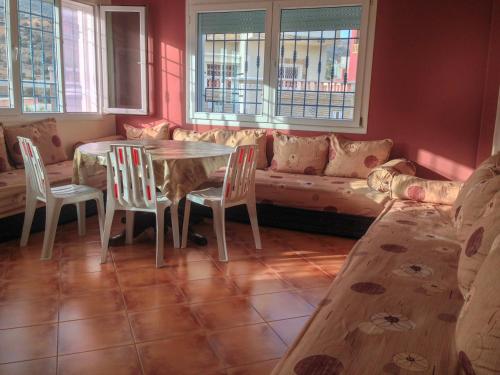 a living room with a table and chairs and a couch at Villa La Palma 2, Imi ouaddar in Imi Ouaddar