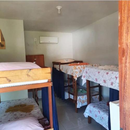 a room with two bunk beds and a table at ITAÚNAS Pousada Nossa Palhoça in Itaúnas