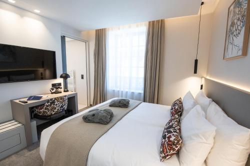 a hotel room with a bed and a television at Best Western Premier Le Chapitre Hotel and Spa in Remiremont