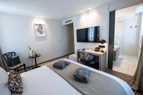 a bedroom with a bed and a television and a bathroom at Best Western Premier Le Chapitre Hotel and Spa in Remiremont