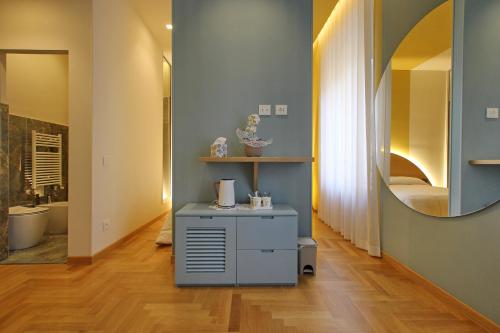 La salle de bains est pourvue d'une coiffeuse avec un miroir et un lavabo. dans l'établissement Dea Rome Suites, à Rome