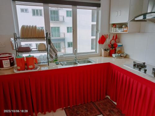 cocina con radiador rojo frente a una ventana en Homestay Triple Q Manjung, en Seri Manjung