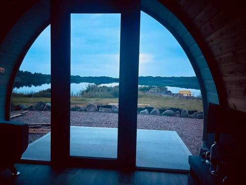 an arched window with a view of a body of water at Wheelhousepods glamping in Donegal