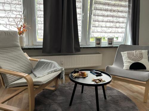 ein Wohnzimmer mit 2 Stühlen und einem Tisch in der Unterkunft Schöne Eigentumswohnung in Kassel in Kassel