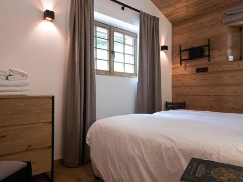 een slaapkamer met een wit bed en een raam bij Appartement Rémy - at the foot of the slopes in Saint-Gervais-les-Bains