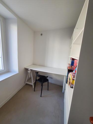 Habitación pequeña con escritorio y silla. en T2 Autonome, centre ville proche Cathédrale en Toul
