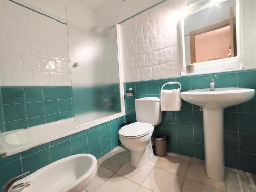 een badkamer met een toilet, een wastafel en een bad bij CHECK-IN CASAS Pico de las Nieves in Benasque