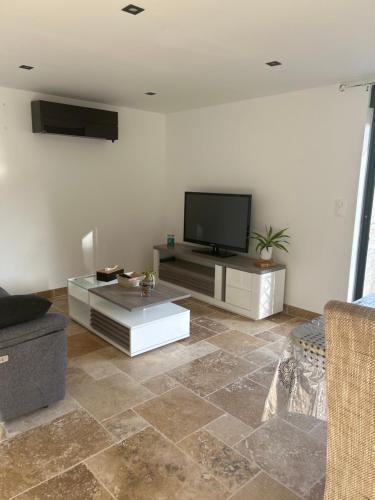 a living room with a flat screen tv and a couch at Chez Anabelle in Saint-Éloi
