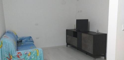 sala de estar con sofá y TV en La casa di Donna Zaira, en Valsinni