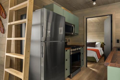 a kitchen with a stainless steel refrigerator and a ladder at Hidden Acres Vestur Cabin in Petoskey
