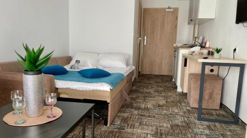 a small room with a bed and a table with wine glasses at Apartament Welle Lazurowy PREMIUM Grzybowo in Grzybowo