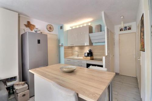 une cuisine avec une table en bois et un réfrigérateur dans l'établissement Appartement & grande terrasse - proche plage, à La Ciotat
