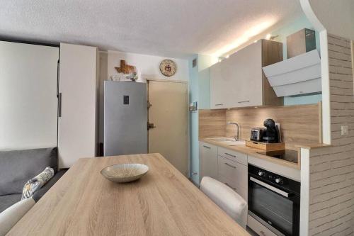 - une cuisine avec une table en bois et un bol dans l'établissement Appartement & grande terrasse - proche plage, à La Ciotat