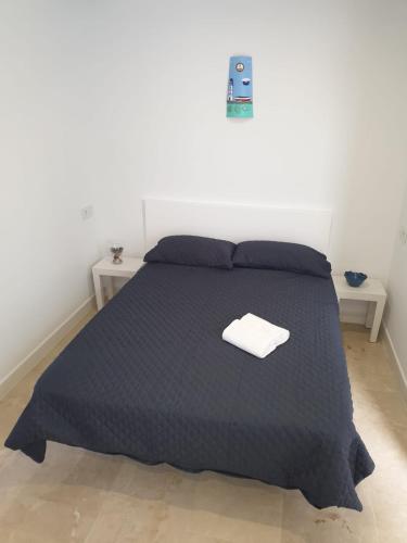 una camera da letto con un letto con un piumone nero di REYNURBAN a Castillo de Sabinillas