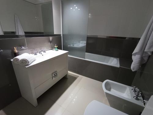 a bathroom with a sink and a toilet and a tub at Departamento Elena 2 in Santa Rosa
