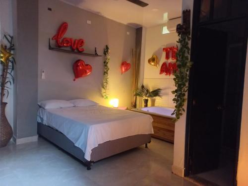 ein Schlafzimmer mit einem Bett und einem Spiegel mit Herzen an der Wand in der Unterkunft CasaSpa in La Dorada