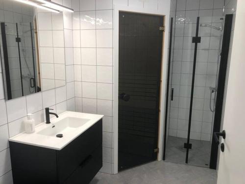a bathroom with a sink and a shower with a mirror at Leilighet i Oppdal - 4 soverom, 2 stuer og 2 bad in Oppdal