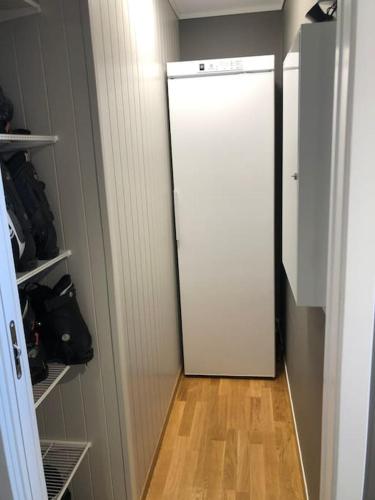a white refrigerator in a room with a wooden floor at Leilighet i Oppdal - 4 soverom, 2 stuer og 2 bad in Oppdal