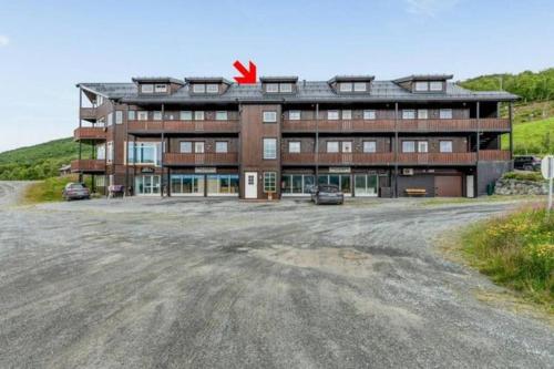 a large brown building with a red x on top at Leilighet i Oppdal - 4 soverom, 2 stuer og 2 bad in Oppdal