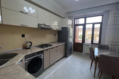 uma cozinha com um fogão, um lavatório e uma mesa em Spacious Rooms em Baku