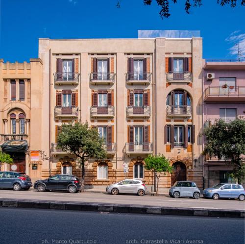 um prédio de apartamentos com carros estacionados em frente em 360Me Palace em Messina
