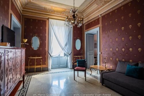 a living room with a couch and a chandelier at 360Me Palace in Messina