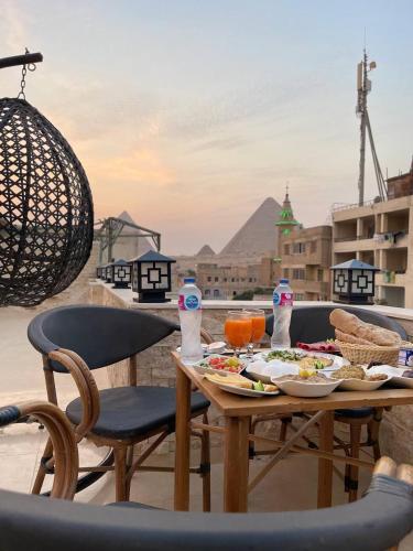 a table with a plate of food on a balcony at Locanda Pyramids Hotel in Cairo