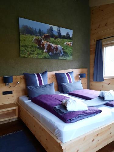 1 dormitorio con 2 camas con vacas en un campo en Herzbluad Chalet en Wallgau