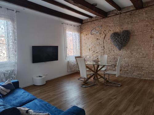 - un salon avec une table et un mur en briques dans l'établissement Ca' Monica Apartment, à Venise