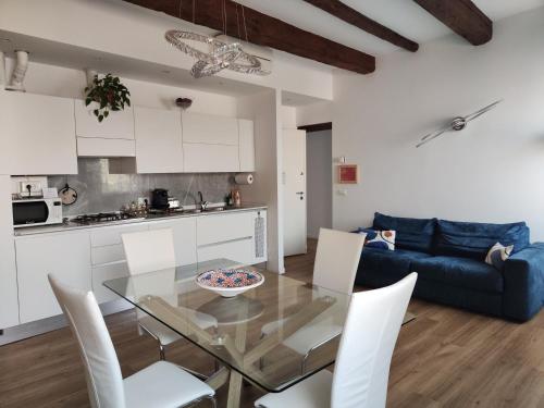 eine Küche und ein Wohnzimmer mit einem Glastisch und Stühlen in der Unterkunft Ca' Monica Apartment in Venedig