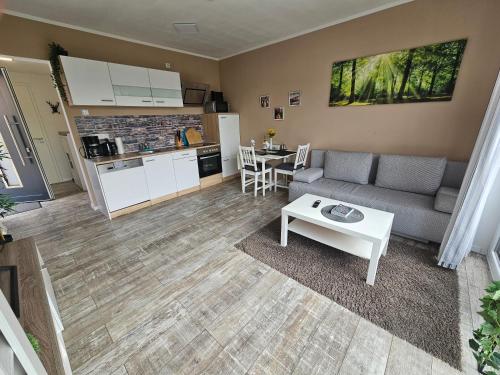 uma sala de estar com um sofá e uma mesa em Haus am Brunnen Wohnung 1 em Klosterkumbd