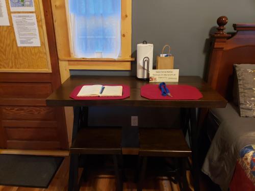 a desk in a room with a bed and a table with pens at Acorn Cottage at Hocking Vacations in Logan