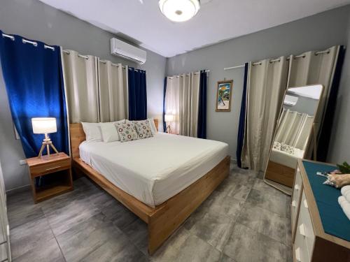 a bedroom with a bed and a lamp and blue curtains at Casa Lambí in Cabrera