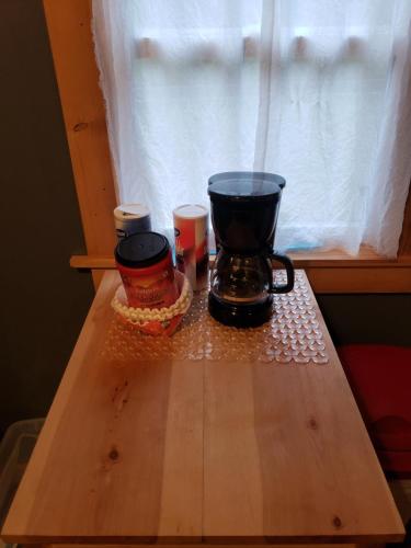 Una mesa con cafetera y dos tazas. en Acorn Cottage at Hocking Vacations en Logan