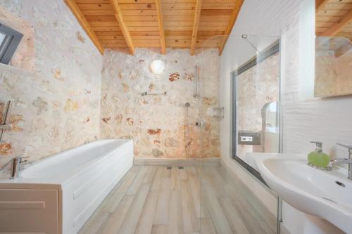 een badkamer met een wit bad en een wastafel bij Villa Taş Ev in İslâmlar