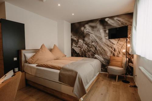 a bedroom with a bed with a painting on the wall at Boutique Hotel Haus Marie in Gerabronn