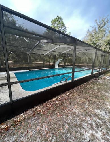 a swimming pool in a building with glass walls at Sunrise Hideaway in Crystal River