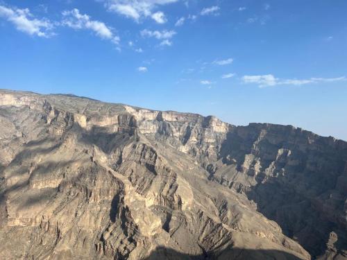 a view of a rocky mountain with a blue sky at Balcony walk rest house Jabal shams in Sa‘ab Banī Khamīs