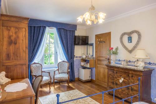 un salon avec une table et des chaises et une fenêtre dans l'établissement Les Anges Rêveurs, à Neuville-aux-Bois