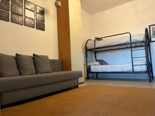 ein Wohnzimmer mit einem Sofa und Etagenbetten in der Unterkunft Appartamento Bella Vista -Malpensa Airport-Leonardo Accademy in Varallo Pombia