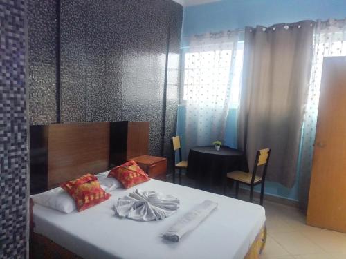 ein Schlafzimmer mit einem Bett und einem Tisch in einem Zimmer in der Unterkunft CHIP RESIDENCIAL in Luanda