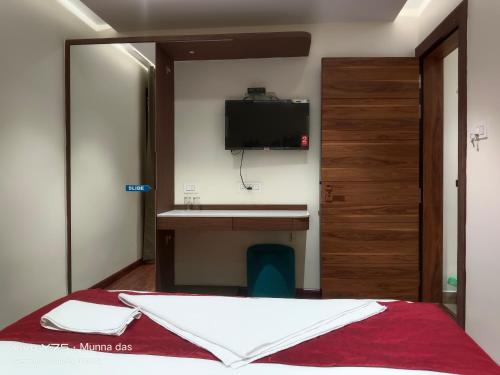 a bedroom with a bed and a tv on the wall at The Pride in Jamshedpur
